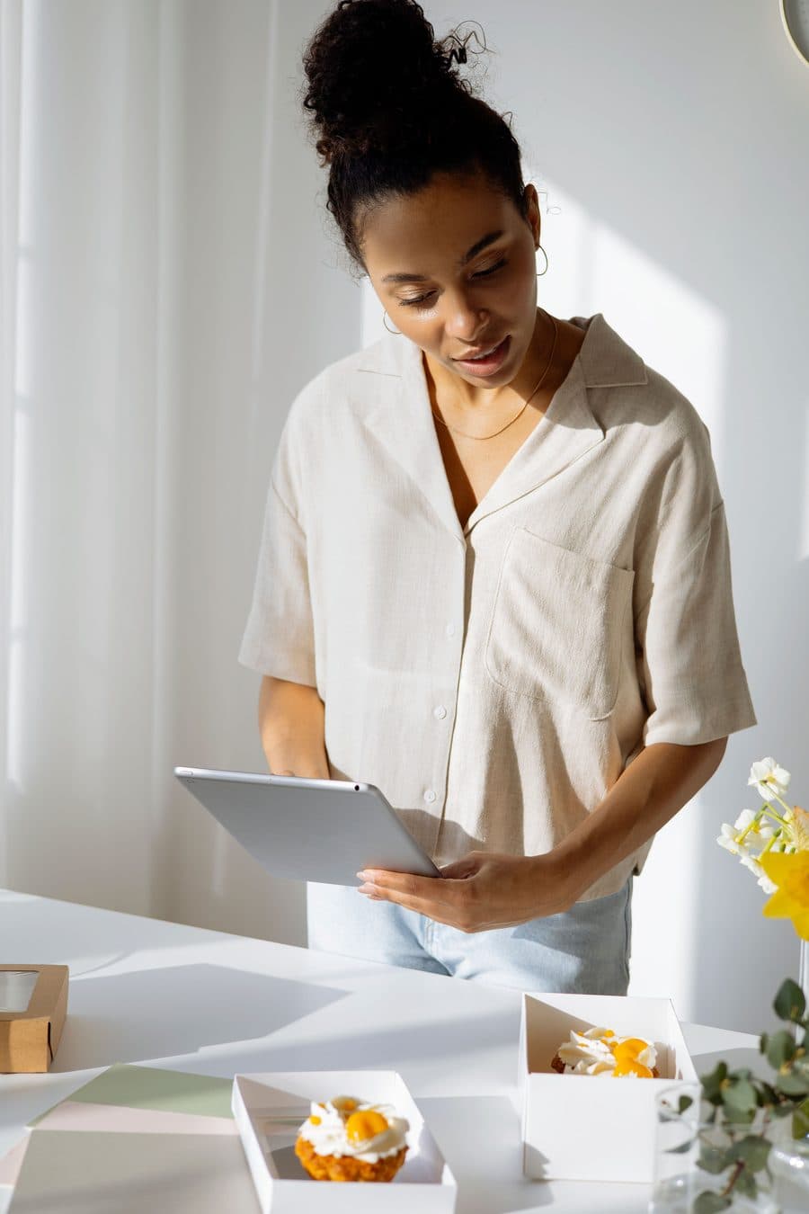 Empreendedora conferindo pedidos no tablet, tranquila e organizada